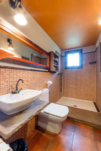 a bathroom with a sink and a toilet and a tub at Apartamentos Rurales & Spa La Bárcena in Enterria