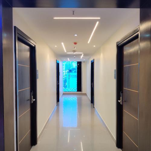 a corridor of a building with doors and lights at Ravila Grand Hotel in Lingampalli