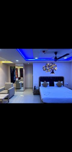 a bedroom with a bed and a couch and blue lights at Ravila Grand Hotel in Lingampalli
