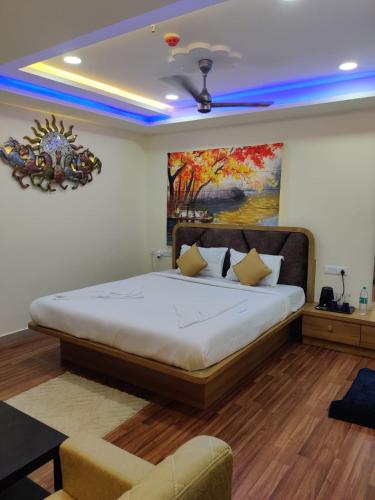 a bedroom with a bed with a painting on the wall at Ravila Grand Hotel in Lingampalli