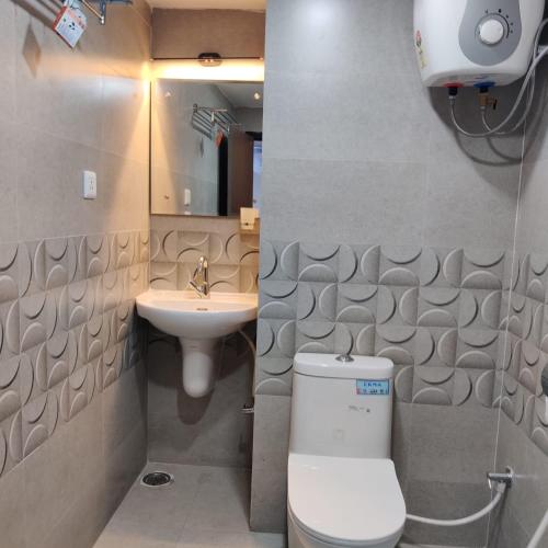 a bathroom with a toilet and a sink at Ravila Grand Hotel in Lingampalli