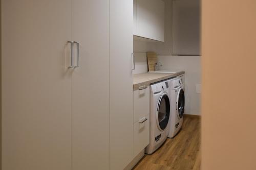 a kitchen with a washer and dryer in it at Leos Chalet in Valdaora di Sopra