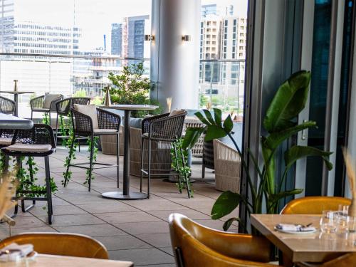 a restaurant with tables and chairs and windows at Conrad Nashville in Nashville