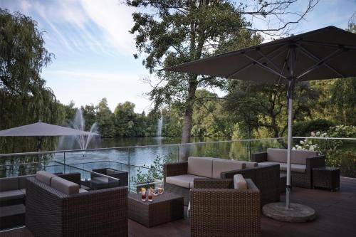 a patio with chairs and an umbrella and a fountain at Hilton Frankfurt Gravenbruch in Gravenbruch