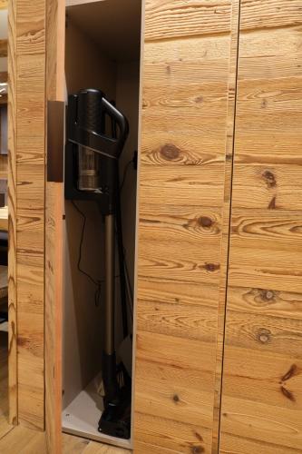 a vacuum cleaner in a closet next to a wooden cabinet at Leos Chalet in Valdaora di Sopra