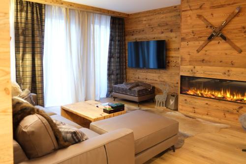 a living room with a couch and a fireplace at Leos Chalet in Valdaora di Sopra