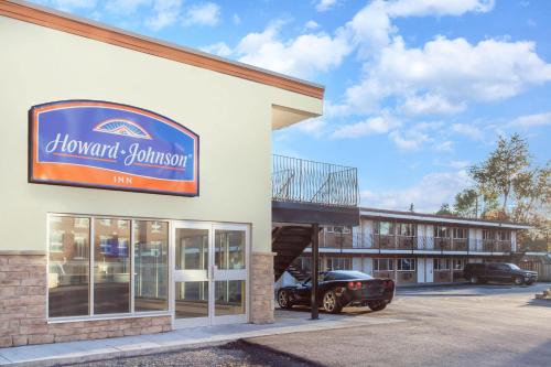 a front of a hotel with a car parked outside at Howard Johnson Inn by Wyndham Kingston in Kingston