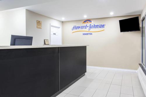 a reception desk in a dental office with a sign on the wall at Howard Johnson Inn by Wyndham Kingston in Kingston