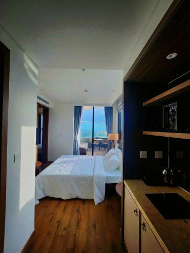 a bedroom with a bed and a view of the ocean at Phan Nguyên Mandala Mũi Né in Mui Ne