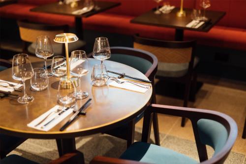 a table in a restaurant with wine glasses on it at The Marcus Portrush, Tapestry Collection By Hilton in Portrush