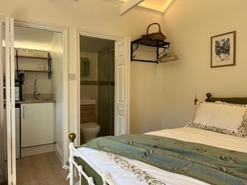 a bedroom with a bed and a bathroom at The Resting Shepherd in Angmering