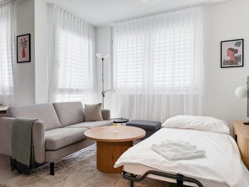 a living room with a couch and a bed at STAYY Flagship Limmattal - contactless check-in in Schlieren