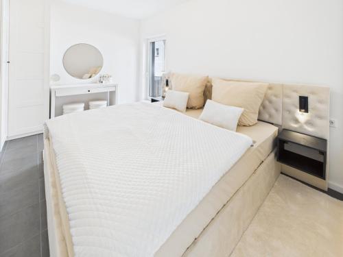 a large white bed in a white bedroom at Loft and Living Private Spa am See mit Sauna und Whirlpool in Braunsbedra