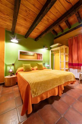 a bedroom with a large bed with green walls at Apartamentos Rurales & Spa La Bárcena in Enterria