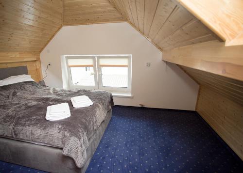 a bedroom with a bed with two white towels on it at Agroturystyka SzumyNowiny in Majdan Sopocki