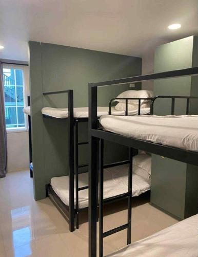 a room with three bunk beds in a room at HOOD Hostel Jomtien in Jomtien Beach