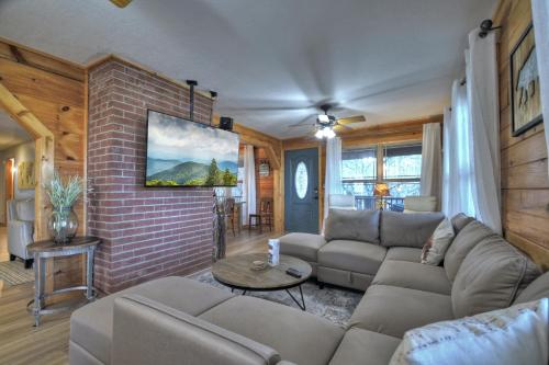 a living room with a couch and a brick wall at Moon Tower Cabin - Beautiful Water Views Firepit More in Blairsville
