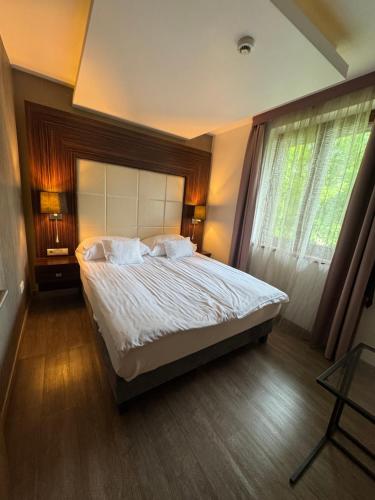 a bedroom with a large bed and a window at Duna Garden Hotel in Budapest
