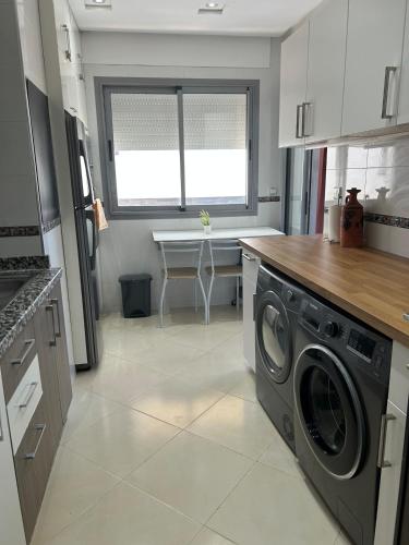 a kitchen with a washer and dryer in it at Blue Space Malabata in Tangier