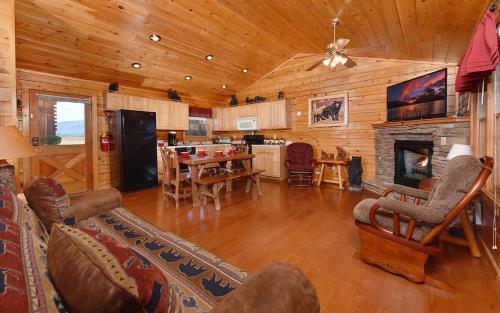a large living room with a fireplace and a kitchen at Bear Footin Heaven in Pigeon Forge