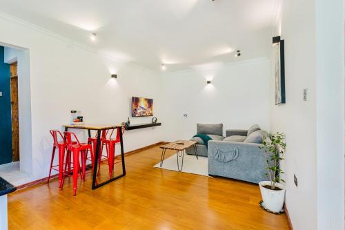 a living room with a couch and a table and chairs at Chique 1BR Villa with Lush Garden Nakuru Town in Nakuru