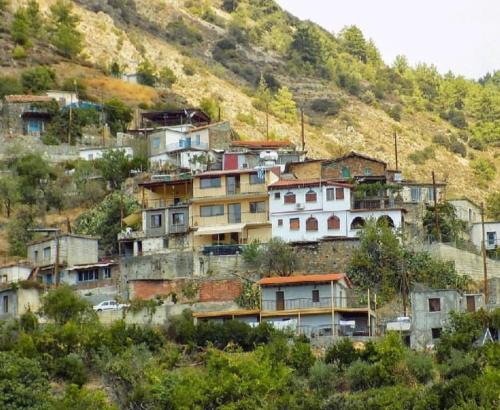 a group of houses on the side of a hill at Lasmari's Bouquet in Sykopetra