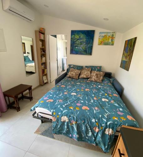 a bedroom with a bed with a blue comforter at Maisonnette de Jardin in Marseille