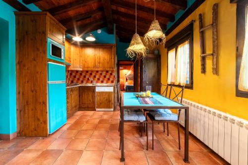 a kitchen with a table and chairs in a room at Apartamentos Rurales & Spa La Bárcena in Enterria