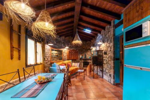 a kitchen and living room with a stone wall at Apartamentos Rurales & Spa La Bárcena in Enterria