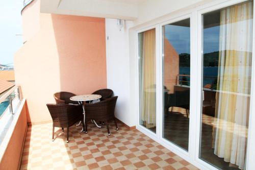 a balcony with a table and chairs on a balcony at Apartments Hari Tisno in Tisno