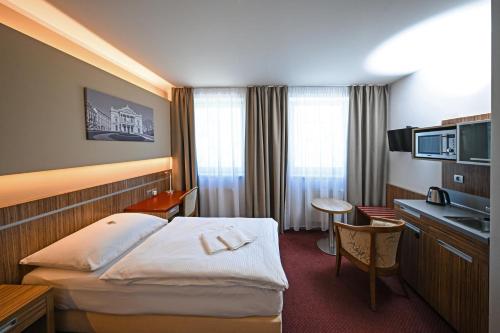 a hotel room with a bed and a sink at Hotel Vaka in Brno