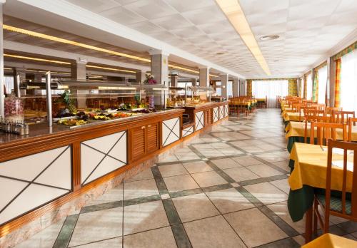 エル・アレナルにあるHotel Riutortのテーブルと椅子のあるビュッフェラインのあるレストラン