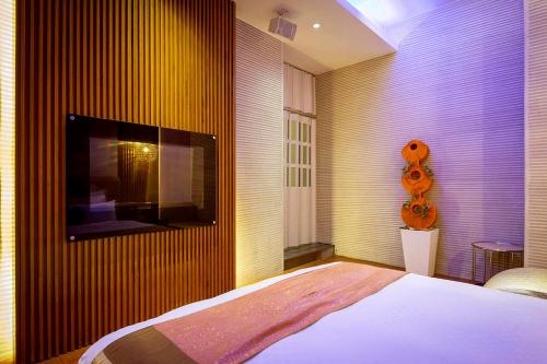 a bedroom with a bed and a tv on a wall at Norway Forest Villa Motel in Taipei