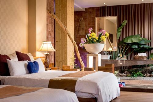a hotel room with two beds and a vase of flowers at Norway Forest Villa Motel in Taipei