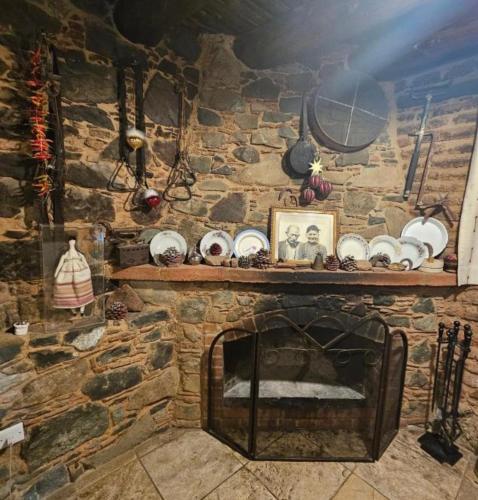 a stone wall with a fireplace with a shelf above it at Lasmari's Bouquet in Sykopetra