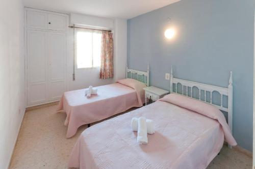 ガンディアにあるPiropoのベッドルーム1室(ピンクのシーツが備わるベッド2台、窓付)