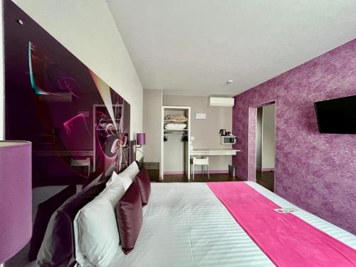 a purple bedroom with a bed with a pink wall at The Originals City - Hôtel Saint-Martial, Limoges Centre in Limoges