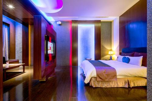 a bedroom with a bed and a tv in it at Norway Forest Villa Motel in Taipei
