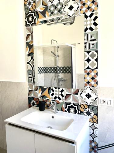 a bathroom with a sink and a mirror at Palazzo Galante in Ginosa Marina