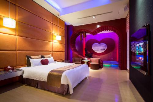 a bedroom with a bed with a heart on the wall at Norway Forest Villa Motel in Taipei