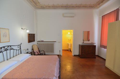 a bedroom with a bed and a dresser and a desk at Corte Fitti guest house in Suzzara