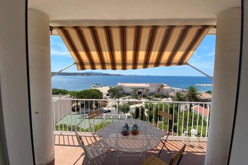 a balcony with a table and a view of the ocean at T3 refait à neuf vue mer en centre ville parking in Bandol