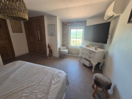 a bedroom with a bed and a desk and a television at Gites Colline De Sollies in Salernes