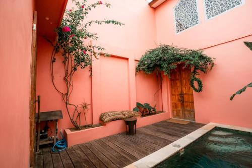 a house with a swimming pool and pink walls at La Marrocco Villas in Nusa Penida