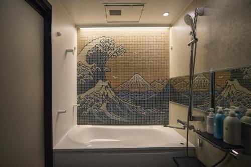 a bathroom with a bath tub with a painting on the wall at Tsubomi Shibuya in Tokyo