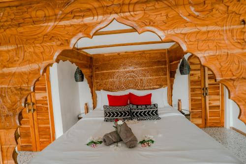 a bedroom with a wooden bed with red pillows at La Marrocco Villas in Nusa Penida