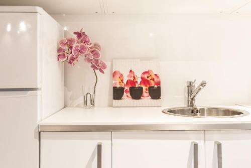 a kitchen counter with a sink and a vase with flowers at Radas in Barcelona