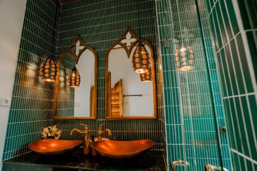 a bathroom with two copper sinks and a mirror at La Marrocco Villas in Nusa Penida