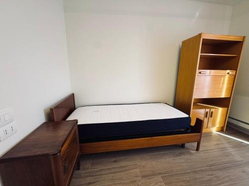 a small bedroom with a bed and a book shelf at Residenza esclusiva appena costruita in Imola