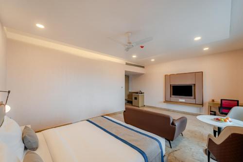 a hotel room with a bed and a flat screen tv at Pravasa Hotel Vijayapura in Bijāpur